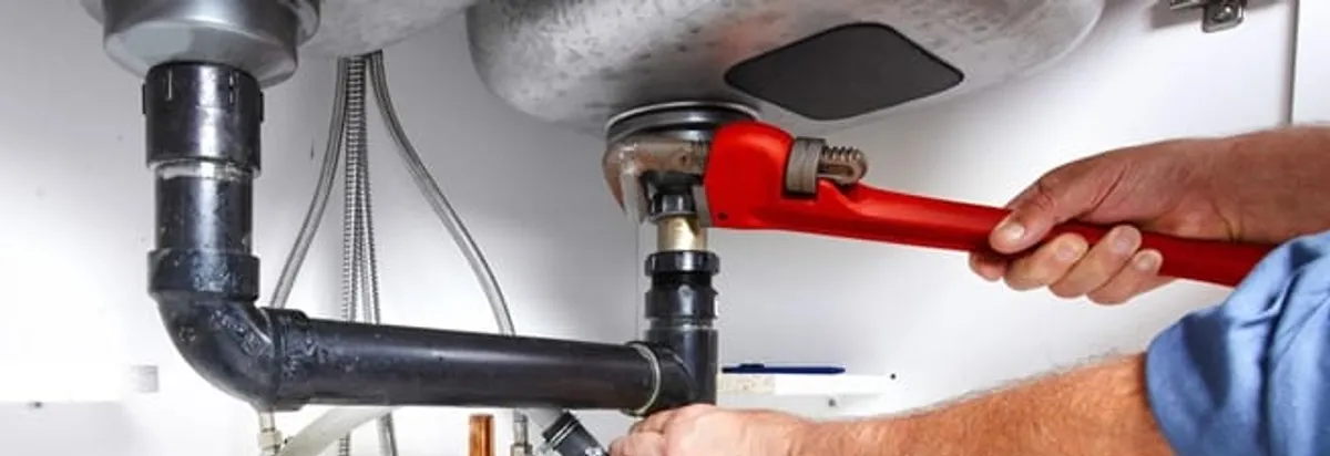 Garbage disposal repair technician tightening the sink drain and disposal connection in Peoria, IL