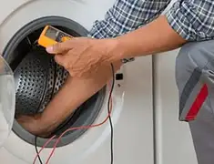 Washing machine repair technician testing a front-load washer with diagnostic tools in Peoria, IL